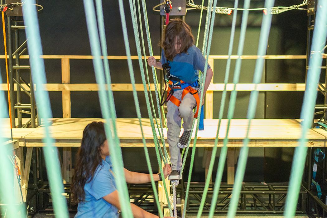 Child walking the rope course in Survival the Exhibition at the Farmington Museum